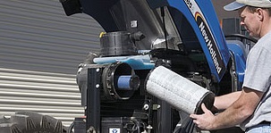 A man clean a air filter of a tractor