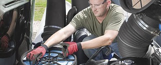 A man clean a air filter of a tractor